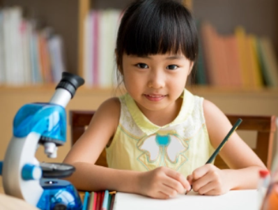 Child with a microscope, exploring STEAM activities