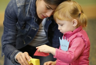 Caregiver and child playing blocks at an early learning event at the library