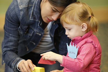 Caregiver and child playing blocks at an early learning event at the library (Links to Birth to 5 resources)