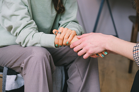 Person holds the hand of another person in distress (Links to the South Sound 2-1-1 database of resources)