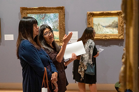 Three people admire art at the museum (Links to Museum Passes information)