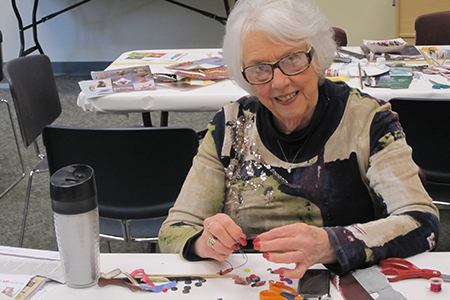 Older person making crafts at library event
