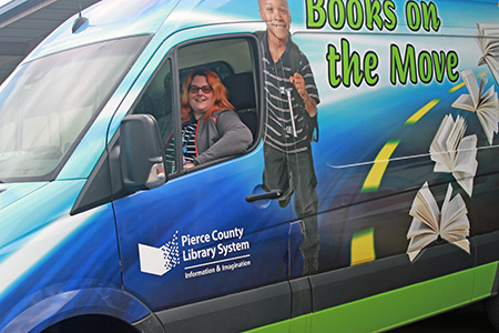 Friendly librarian takes books out to people in the community through Pierce County Library's Outreach Services (Links to Outreach Services)