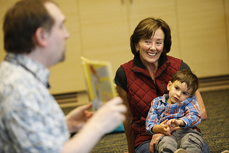Caregiver and child enjoy a book during story time.