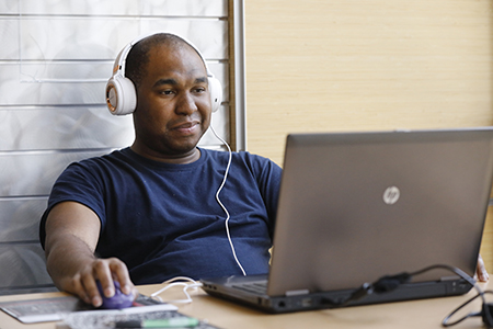 Adult working on laptop in the library