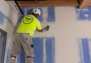 Worker sanding drywall