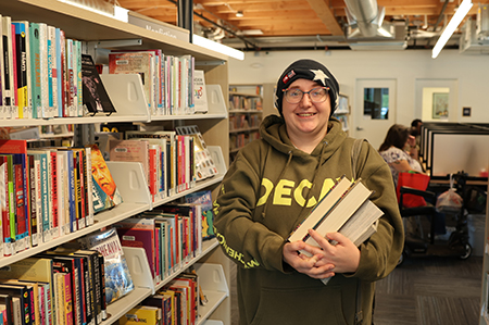 Library cardholder with arm full of books