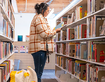 Adult with an infant explores the books at the library